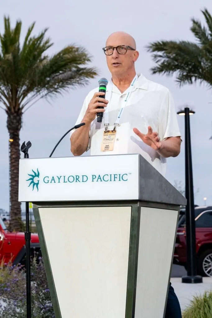 A speaker with a microphone at the Gaylord Pacific podium during the Marzul grand opening