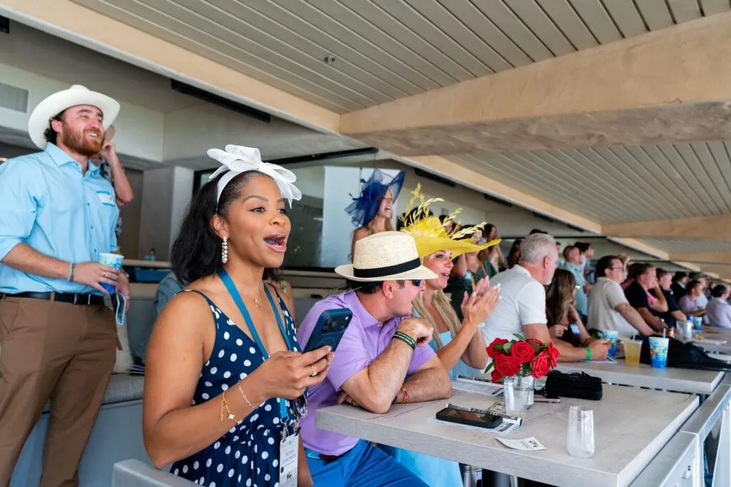 Guests laughing in the grandstand suite at the Surf and Turf event at the Del Mar Fairgrounds