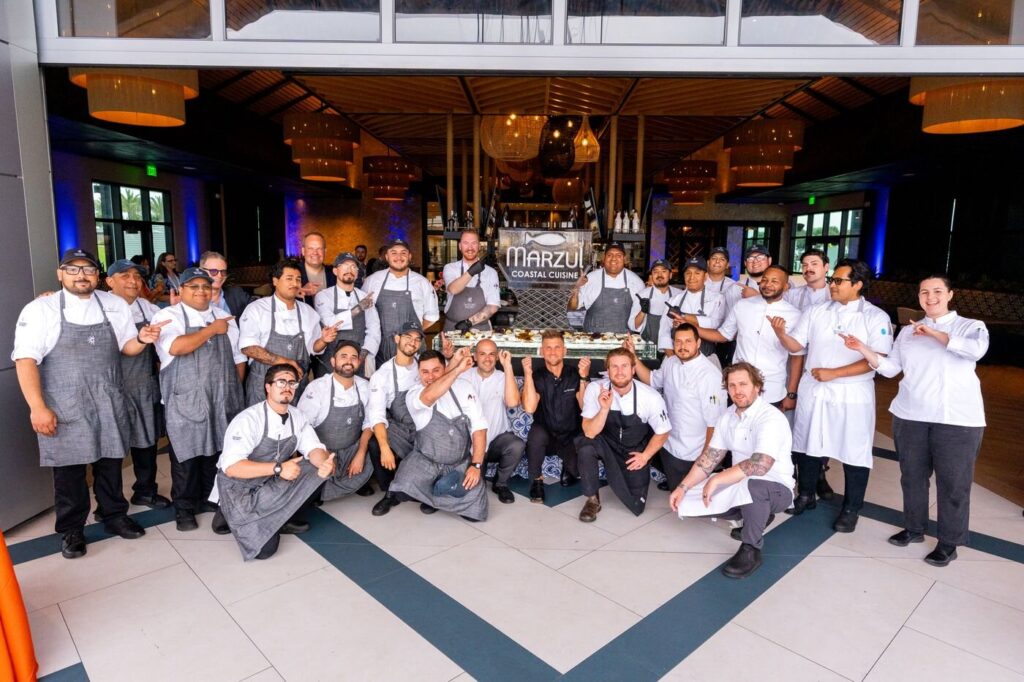The whole Marzul kitchen crew posing under the restaurant sign on opening night