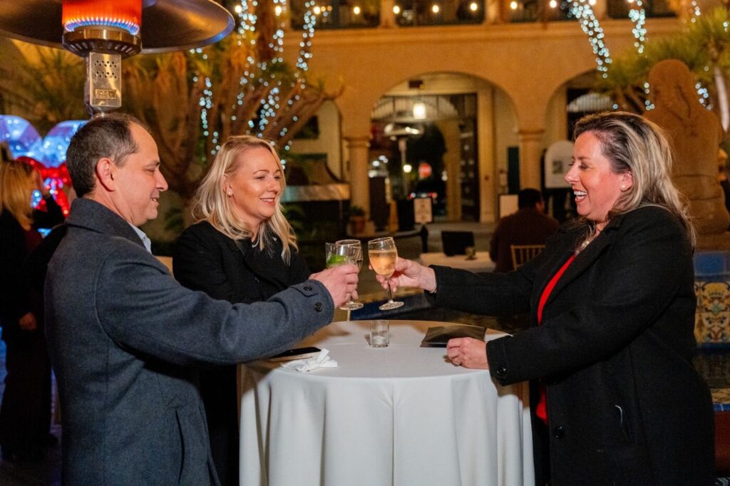 Guests raising a toast at a company holiday party at the Prado in Balboa Park