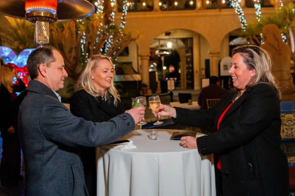 Guests raising a toast at a company holiday party at the Prado in Balboa Park