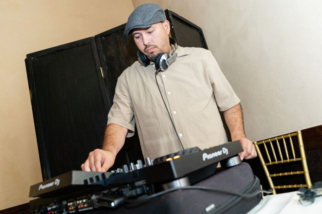 The DJ working the decks at a company holiday party at the Prado