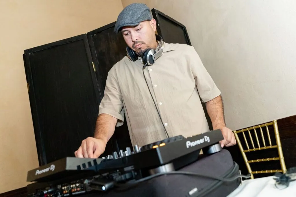 The DJ working the decks at a company holiday party at the Prado