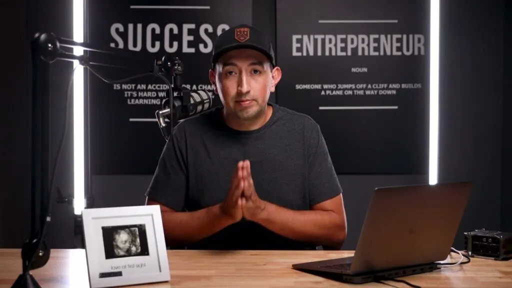 David at his desk in front of an Entrepreneur sign, recording his video review