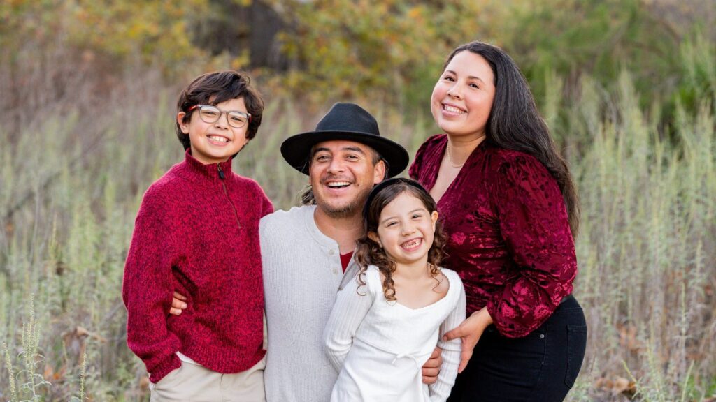 Eddie Flores laughing with his wife and two kids on a fall family shoot at Steele Canyon