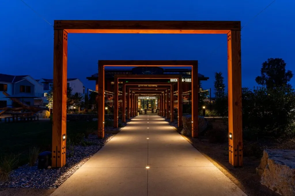 Timber arches over a lit walkway at Fox Point Farms in Encinitas at night