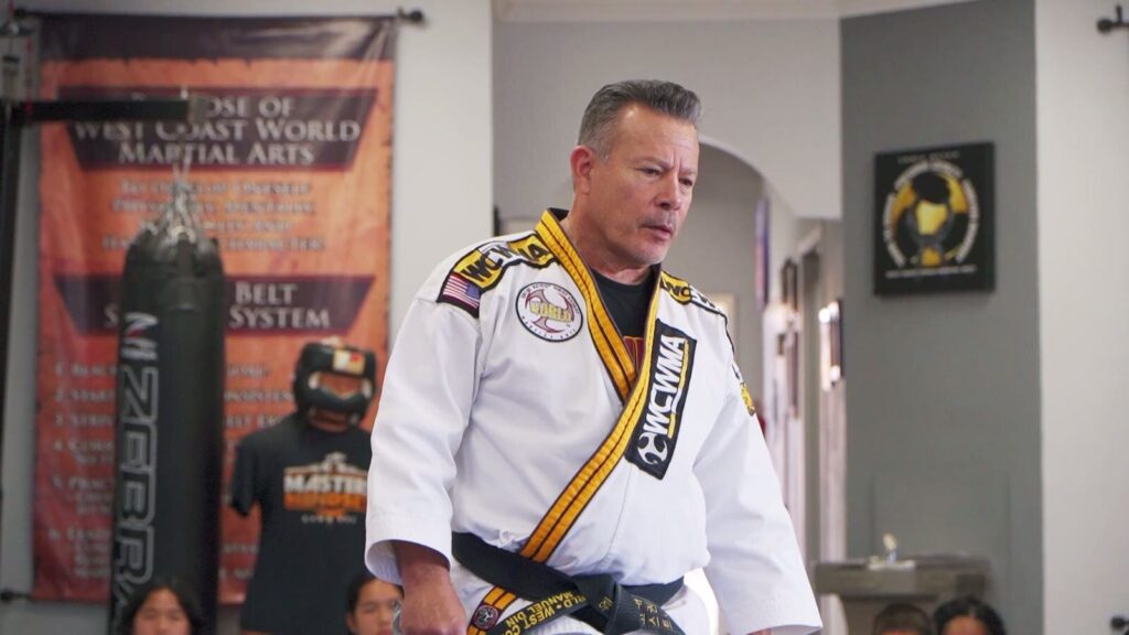 West Coast Martial Arts instructor in a black belt uniform on the mat