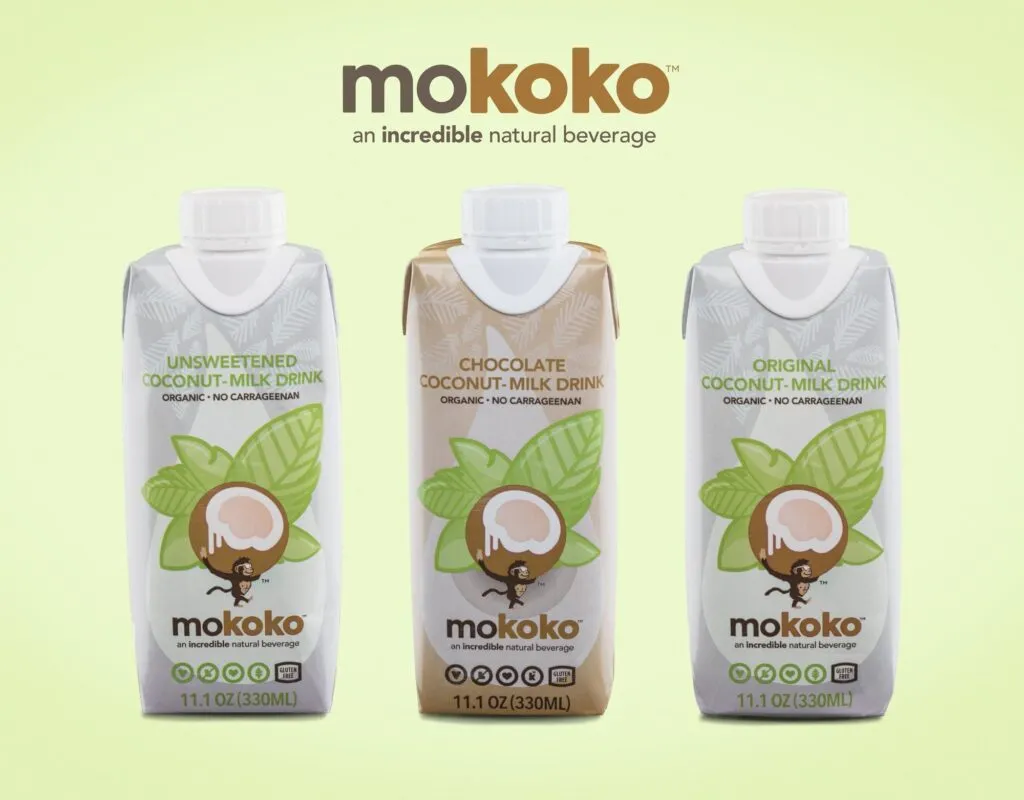Three Mokoko coconut milk drink cartons side by side on a soft green background