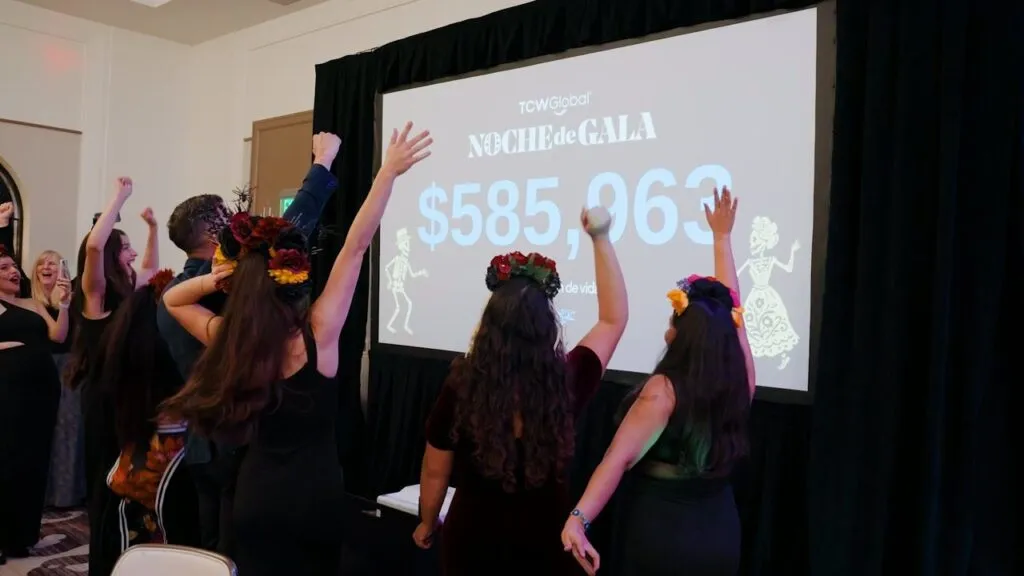 Guests at the Corazón de Vida Noche de Gala in La Jolla throwing their arms up in celebration