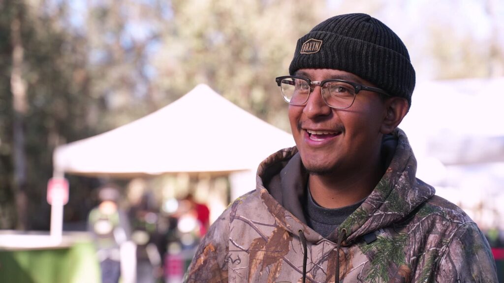 A laughing player in a beanie at a Velocity Paintball birthday party