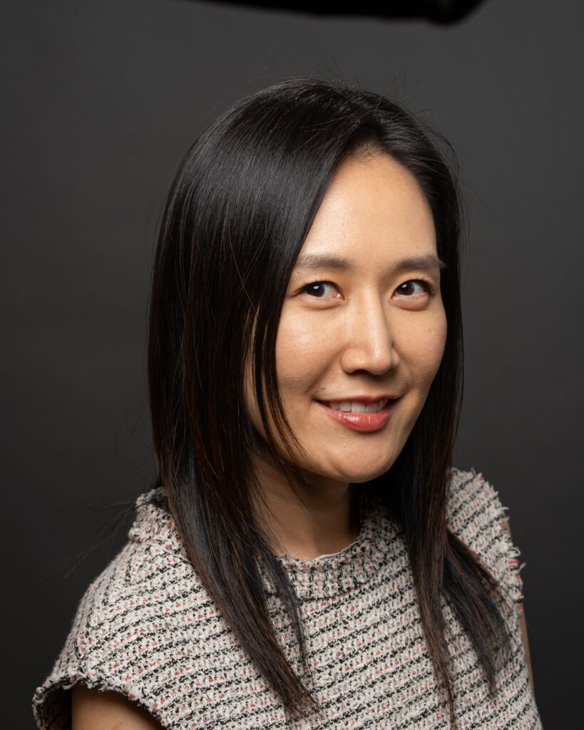 Professional headshot of a woman in a tweed top, soft studio light
