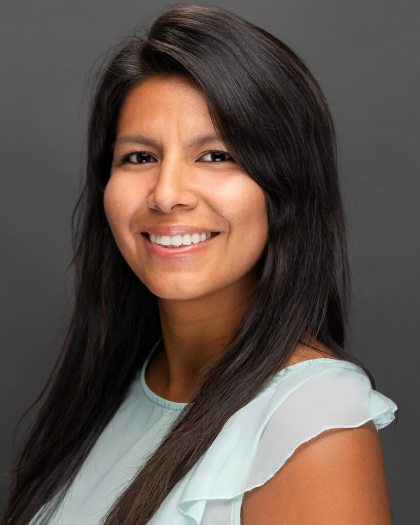 Corporate headshot of a woman with long dark hair in a pale blue blouse