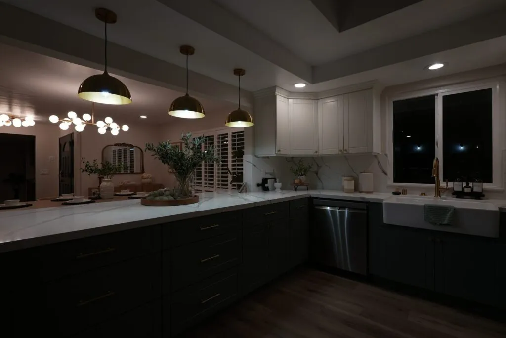 Kitchen at dusk with pendant lights glowing over the island
