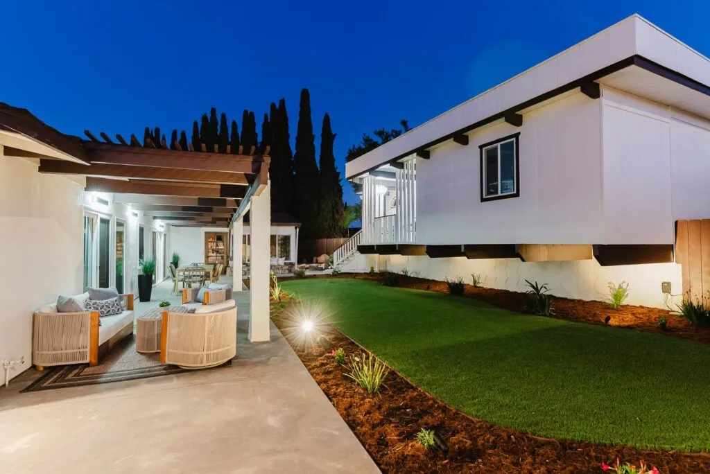 Twilight real estate photo of a La Mesa home, the patio and lawn lit up under a deep blue sky