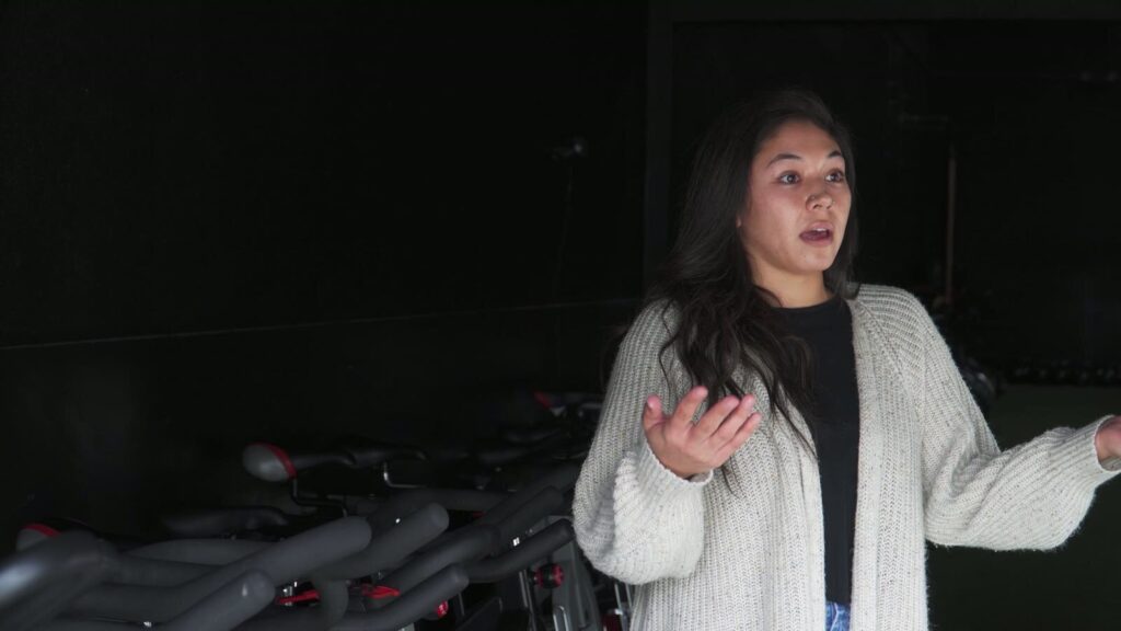 A student of the SDSW program speaking to camera in the gym